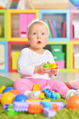 Adorable little child playing with colorful toys 