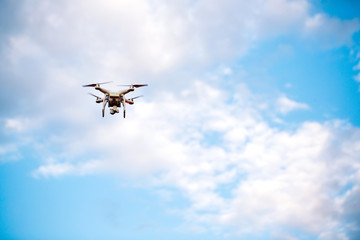 Quadcopter drone with the camera against the blue sky