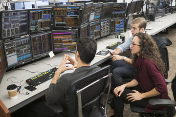 Group of young people analyzing stock market data at trading desk