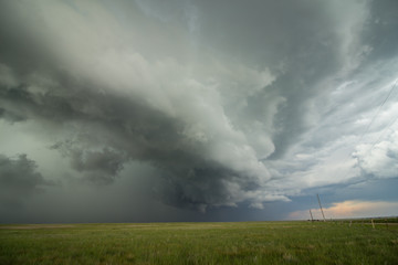 Obraz na płótnie Canvas An arcing shelf cloud races forward as a severe thunderstorm approaches.