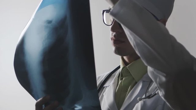 The doctor is studying an X-ray. Medical worker diagnoses