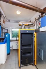 A household boiler room with a boiler on firewood, a barrel; Valves; Sensors and a water treatment system