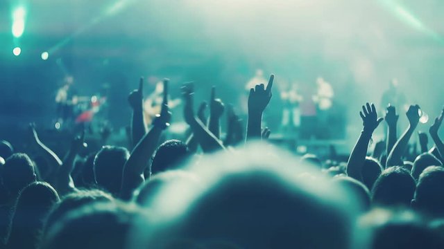 Iconic night rock concert front row crowd cheering hands in air slomo 100p