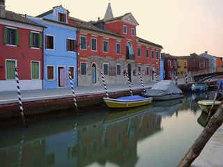 Boats in the canal near the colorful houses of the island of Bur