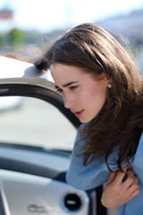 Fototapeta na wymiar A woman stands near an open car door
