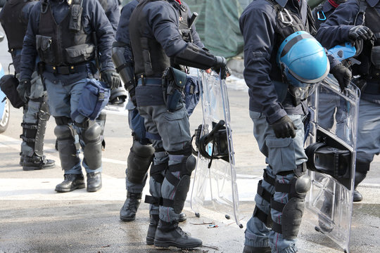 policemen in riot gear with hardhat while patrolling the streets