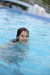 Fototapeta na wymiar Young girl learns to swim in the swimming pool