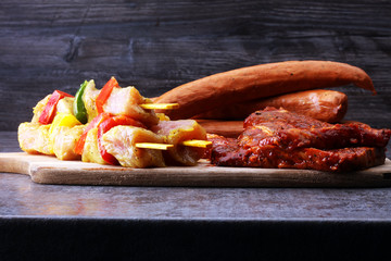 Selection of marinaded meat for bbq grilling with herbs on table