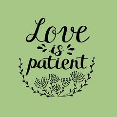 Hand lettering Love is patient, made near flowers.