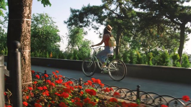young beautiful woman riding a bicycle in a park
