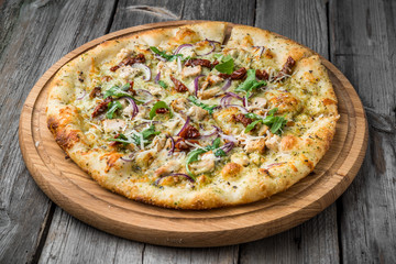 pizza with sun-dried tomatoes, prosciutto, arugula and parmesan cheese