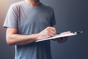 Casual adult male writing notes on notepad paper