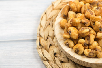 Plate with toasted corn on wooden background.