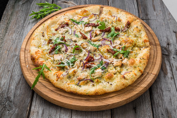 pizza with sun-dried tomatoes, prosciutto, arugula and parmesan cheese