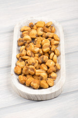 Toasted corn on wooden bowl. Verticall studio shot.