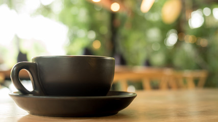 Fresh hot americano coffee in cup without topping on a wooden table with cafe shop background