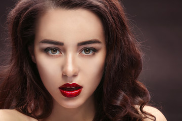 Fototapeta premium Beautiful woman with red lips on dark background