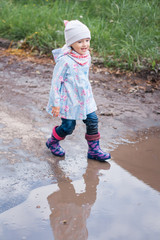Little girl running to the puddle