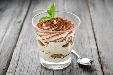 Traditional Italian dessert tiramisu in a glass.
