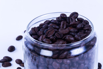 Coffee beans in the jar on dark wood background