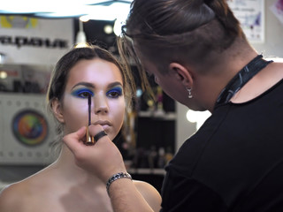 Make-up artist makes art make-up paint at the models eyebrow