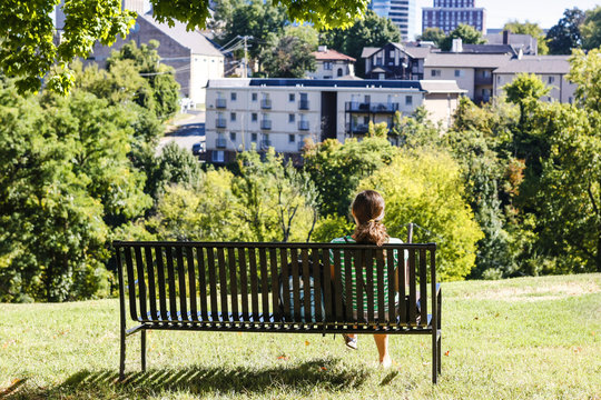 A female University of Tennessee student sits quietly looking at the city of Knoxville from the Hill