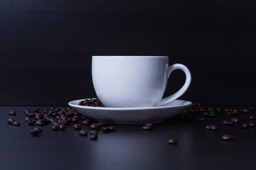 Hot coffee in the white cup and roasted on dark background
