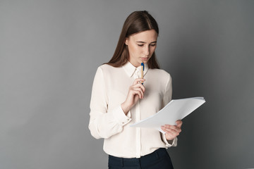 Businesswomen holds documents in her hand. One. Isolated on gray background