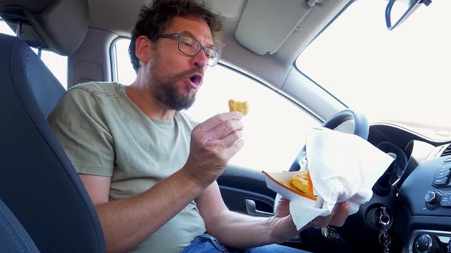 Happy Man Eating Junk Food In Car