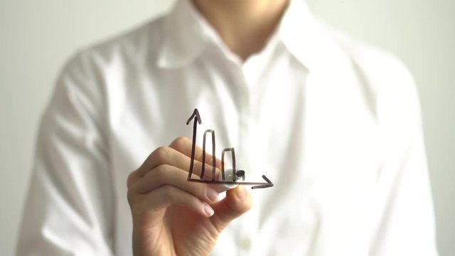 Woman drawing decrease diagram with red down arrow on transparent screen.