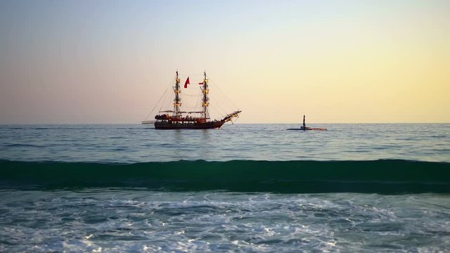Touristic sailboat cruising along Alanya shore on sunset. Gulet is a traditional design of a two-masted wooden sailing vessel from southwestern coast of Turkey, built in the coastal towns of Bodrum an