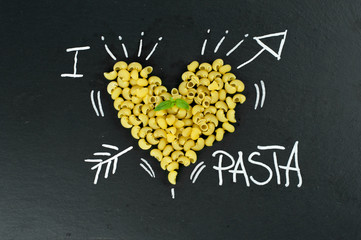 Pasta in the shape of a heart on blackboard. I love pasta concept.