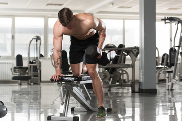 Obraz na płótnie Canvas Bodybuilder Exercising Back With Dumbbells