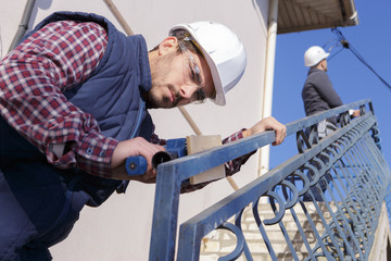 manual worker tightening stairs banisters