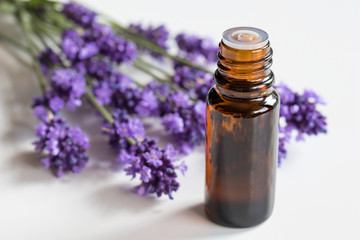 Obraz na płótnie Canvas A bottle of lavender essential oil on a white background