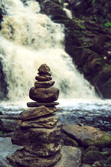 Stone pyramid near a tropical waterfall.