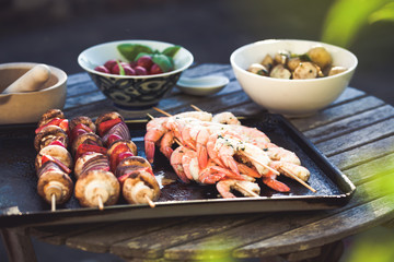 barbecue in the garden - summer- prawns and vegetables on skewers