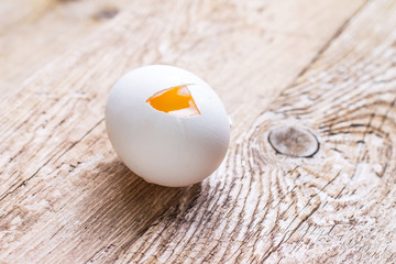 Broken raw egg on wooden background