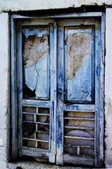 Peeling paint and broken glass in  window of abandoned home  in the village of Doan Cilar, Turkey