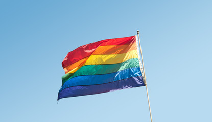GLBTQ Pride Rainbow Flag on blue sky left