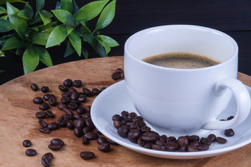 Hot coffee in the white cup and roasted on dark background
