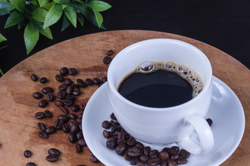 Hot coffee in the white cup and roasted on dark background
