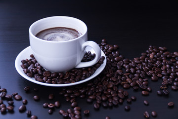 Hot coffee in the white cup and roasted on dark background
