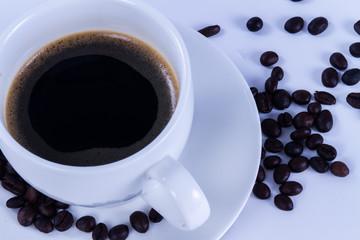 Hot coffee in the white cup and roasted on white background