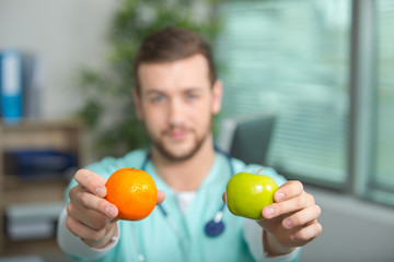 doctor showing a pear and an apple