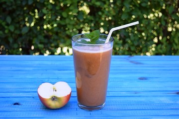 glass of apple, peach smoothie with straw on wooden table. Protein cocktail. Healthy drink. Fresh homemade smoothie. Healthy breakfast of smoothie