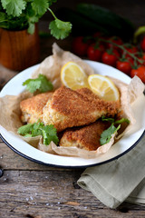 Chicken legs fried in breadcrumbs in deep-fried, rustic style. Old wooden background.