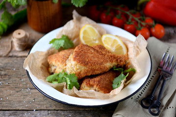 Chicken legs fried in breadcrumbs in deep-fried, rustic style. Old wooden background.