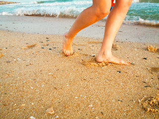 Closeup on woman walking on sandy beach outside background. Natural surface footprints