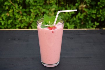 glass of strawberries, cherries smoothie with straw on wooden table. Protein cocktail. Healthy drink. Fresh homemade smoothie. Healthy breakfast of smoothie,